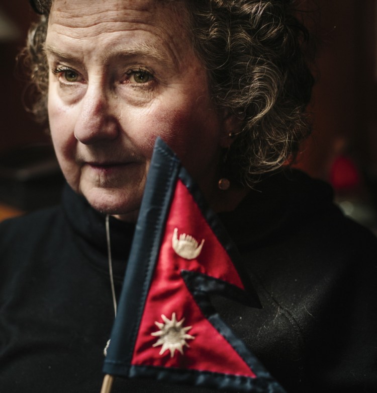 Kathleen Nolan holds a Nepalese flag Monday at her home. Nolan and her guide were hiking in a national park in Nepal, through a narrow river valley with tall mountains on either side, when a quake struck April 25. “There was never a moment when we truly felt safe,” she said.