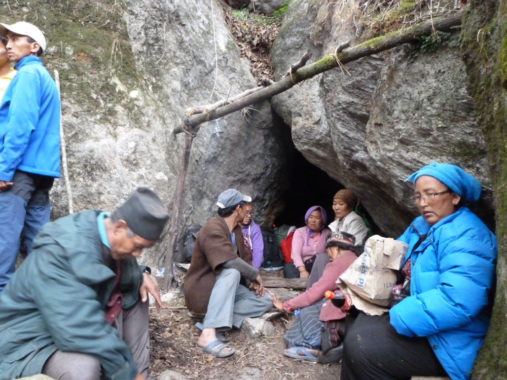 Earthquake survivors sit at the entrance of a cave where they took shelter for one night from landslides. They left the cave the next day and set up camp outside. They cleared rocks to create a potential helicopter landing site, below, using flour to mark the site. After transmitting their coordinates to rescuers, they were eventually airlifted to safety.
