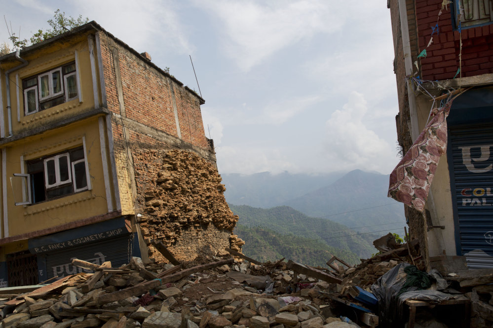 A building damaged in the May 12 earthquake stands tilted in Chautara, Nepal, on Wednesday. Thousands of fear-stricken people spent the night outdoors after a new earthquake killed dozens of people and spread more misery in Nepal, which is still reeling from a devastating quake that killed thousands nearly three weeks ago.