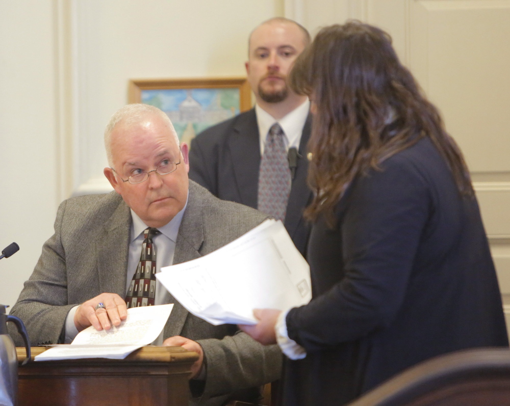 Defense attorney Amy Fairfield, right, presents Eliot Police Chief Theodor Short with documents during a proceeding in February related to allegedly falsified officer patrol reports.