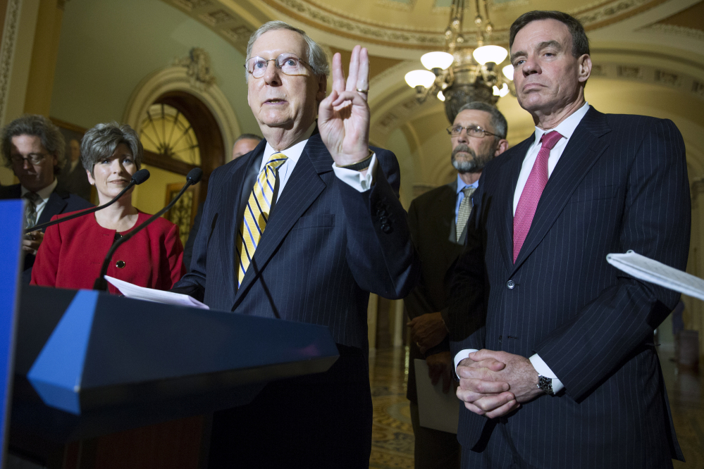 From left, Sen. Joni Ernst, R-Iowa, Senate Majority Leader Mitch McConnell of Ky and Sen. Mark Warner, D-Va., participate in a news conference on Capitol Hill in Washington, Tuesday, May 19, 2015, with small business owner to discuss the Trade Promotion Authority bill. (AP Photo/Evan Vucci)