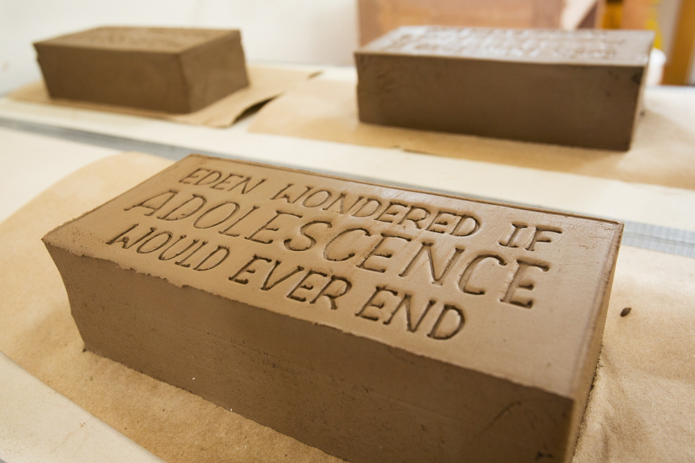 Freshly imprinted bricks telling stories about the India Street neighborhood dry in the artists’ Portland studio. Once done, the bricks will be installed, becoming simple monuments celebrating the lives of ordinary residents.