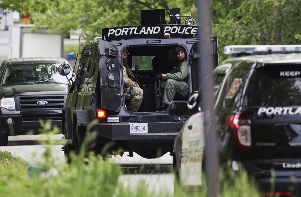 Members of the Portland police Special Reaction Team wait outside a house during Tuesday’s raid near Presumpscot Elementary School.