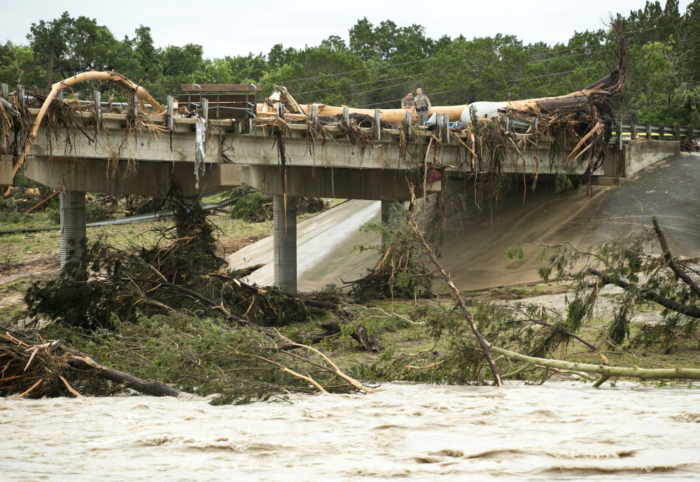 A large tree rests on the Hwy 12 bridge over the Blanco River in Wimberley, Texas, Sunday May 24, 2015. Flooding in Texas and Oklahoma has led to numerous evacuations. 