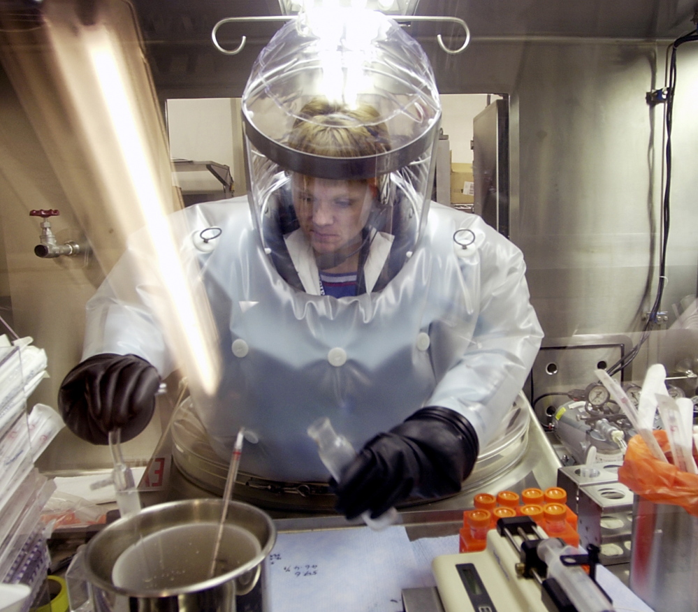 Microbiologist Ruth Bryan works with BG nerve agent simulant in an airtight enclosure also used for hands-on work with anthrax at Dugway Proving Ground in Utah.