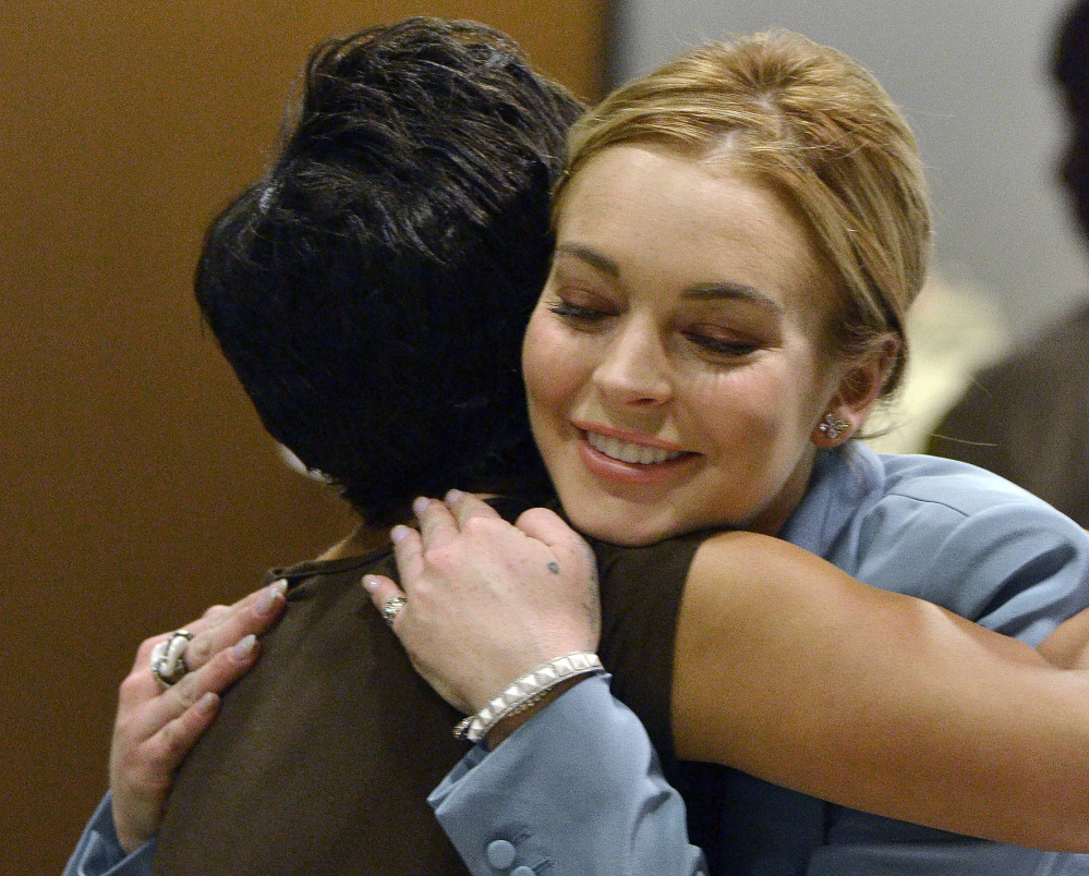Lindsay Lohan embraces her attorney, Shawn Holley, after a progress report on her probation for theft charges in Los Angeles Superior Court in 2012.