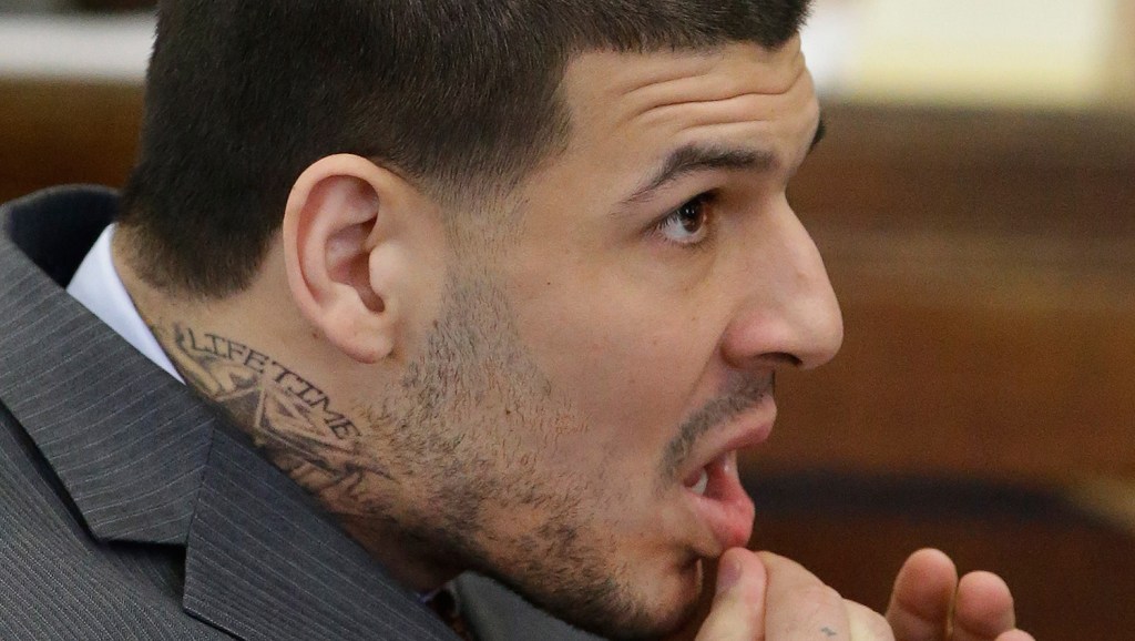 Former New England Patriots star Aaron Hernandez sports a new neck tattoo that includes the word "Lifetime" during his arraignment in Boston on Thursday on a charge of trying to silence a witness in a double murder case against him. Hernandez was convicted last month in the 2013 murder of Odin Lloyd.