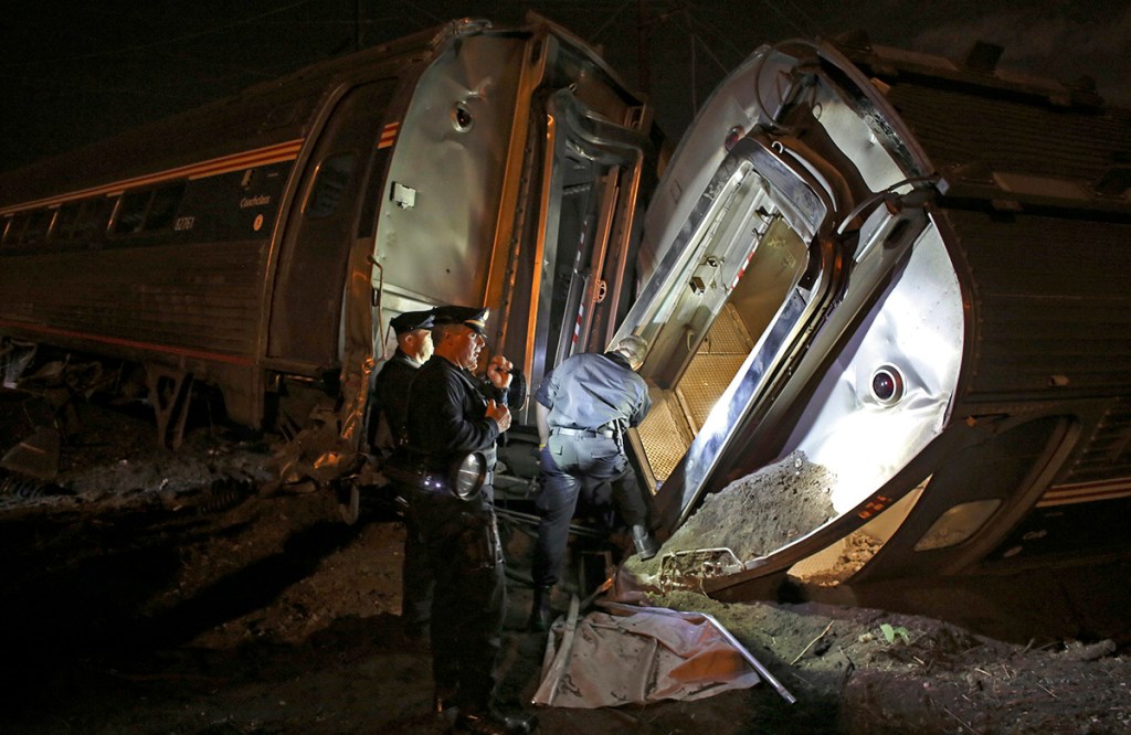 Emergency personnel comb the wreckage of Amtrak train 188 in this  May 12, 2015, photo. The train derailed in Philadelphia on its run to New York City, killing eight and injuring 200 people. Amtrak says it will install video cameras inside locomotive cabs that record the actions of train engineers. The Associated Press