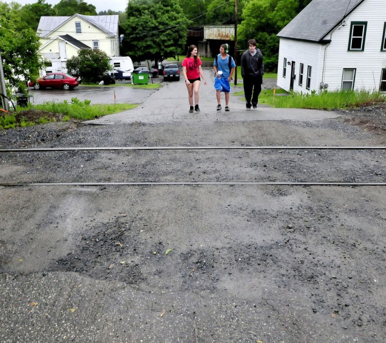 By this summer only foot traffic will be allowed near the railroad tracks on Elm Street in Fairfield after the rail crossing is closed off to vehicle traffic. Vehicles will still have access to homes on either side of the tracks, but won’t be able to cross the tracks. Walking on Monday are, from left, Ashley Leighton, Devyn Fecteau and Mason Worden.