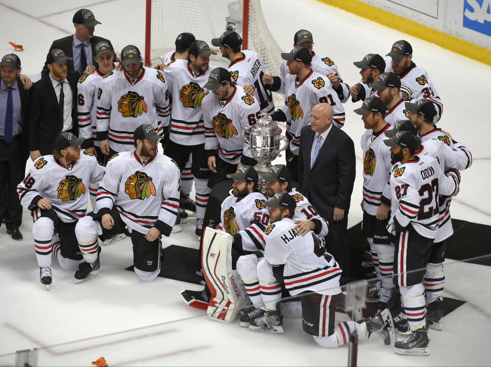Members of the Chicago Blackhawks pose around the trophy after their win against the Anaheim Ducks in Game 7 of the Western Conference final of the NHL hockey Stanley Cup playoffs in Anaheim, Calif., on Saturday. The Blackhawks won 5-3 to advance to Stanley Cup Finals.