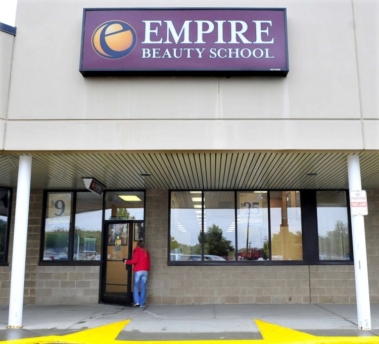 A woman walks into the Empire Beauty School in Waterville on Tuesday. The school is one of six in the country that will close because of declining enrollment.