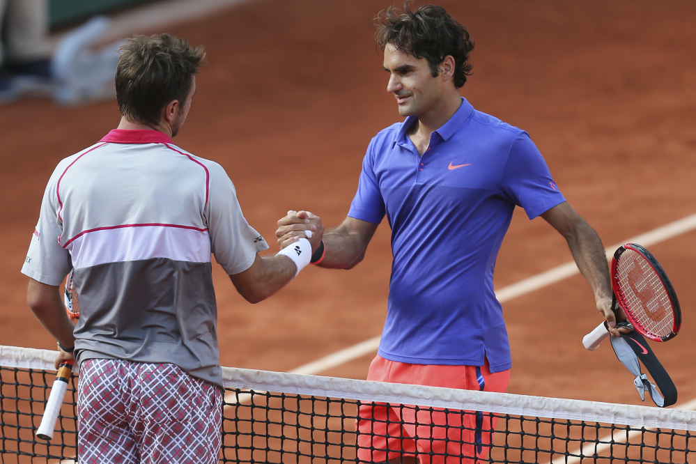 Stan Wawrinka shakes hands with compatriot Roger Federer, right, after winning the quarterfinal match Tuesday of the French Open in three sets 6-4, 6-3, 7-6 (7-4), at the Roland Garros stadium, in Paris, France.