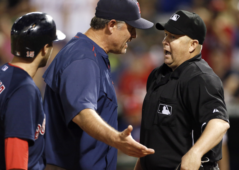 Boston Red Sox manager John Farrell, center, argues a strike three call against Dustin Pedroia, left, to home plate umpire Todd Tichenor last week in Arlington, Texas. Texas won 7-4. Red Sox owner John Henry said the his is disappointed in the team’s play, but added that the jobs of Farrell and GM Ben Cherington are safe.