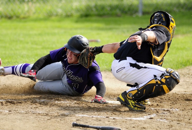 Waterville’s Dan Pooler slides safely into home avoiding te tag by Maranacook catcher Mark Buzzell during a game Wednesday in Readfield.