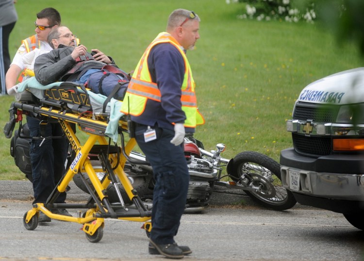 Emergency responders from the Sidney Fire Department and Delta Ambulance treat a motorcyclist whose motorcycle was hit Thursday by a car on West River Road in Sidney.