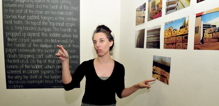 Colby College artist in residence Shirel Horovitz hangs an art exhibit Wednesday by area students she worked with at Common Street Arts in Waterville. The exhibit opened Thursday and runs through Sunday.