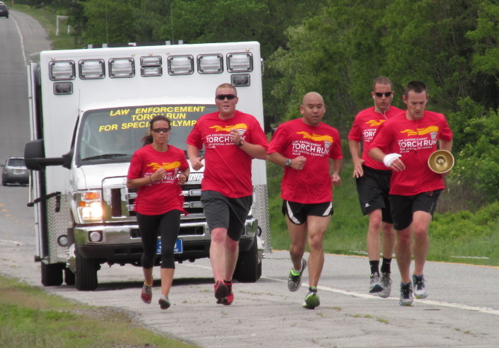 Law enforcement officers carry the Special Olympics torch Thursday down U.S. Route 2. The run began May 26 in Augusta and culminates Friday at the Special Olympics Maine Summer Games in Orono.