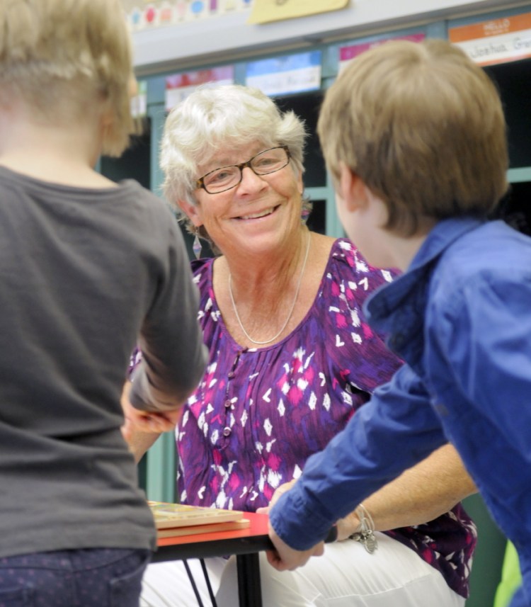 Hall-Dale Elementary School pre-kindergarten teacher Sue Dodge speaks with a pair of students earlier this week after helping them lace their sneakers in her class at the Hallowell school. Dodge is retiring after teaching for more than 40 years at the elementary level at Hall-Dale.
