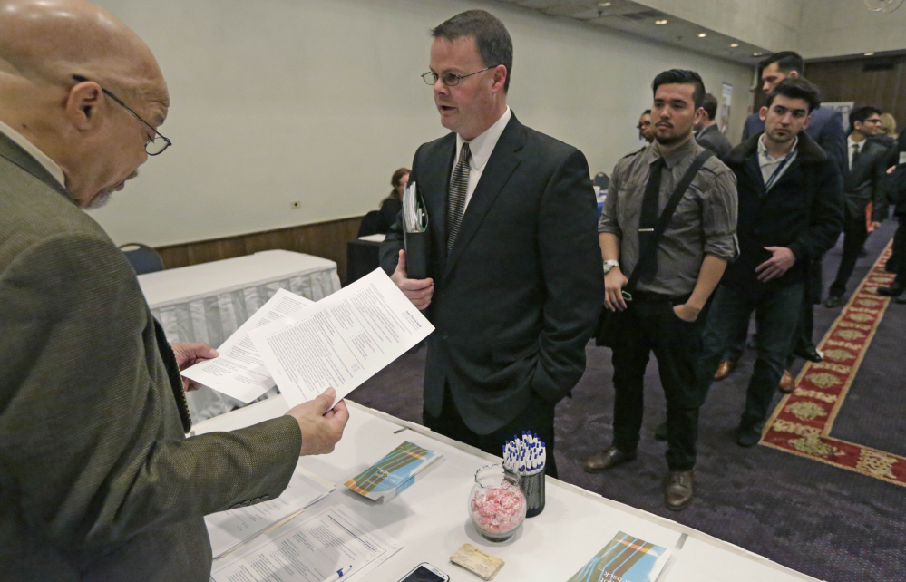 Ralph Logan, general manager of Microtrain, left, speaks with James Smith who is seeking employment during a National Career Fairs job fair in Chicago. The U.S. economy is churning out a lot of jobs but not a lot of financial security for many of the people who hold them.