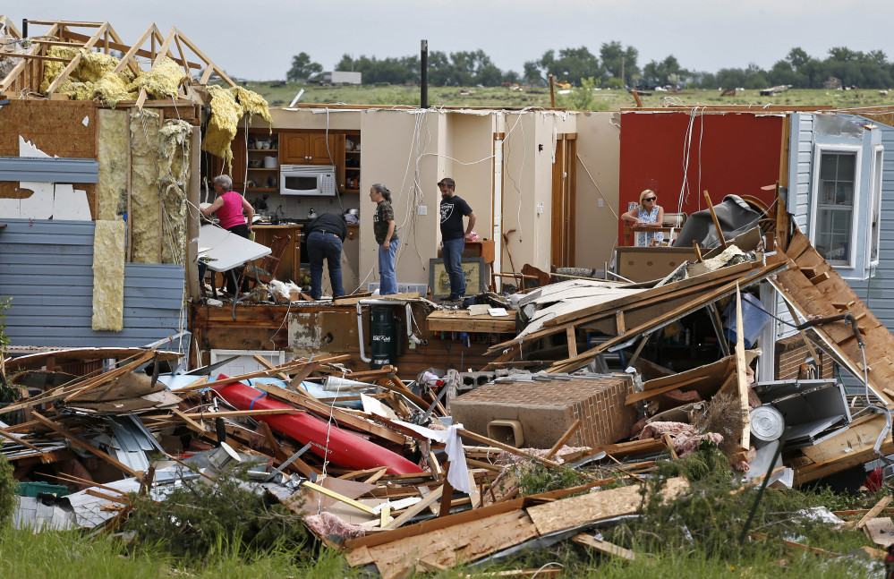 Members of the Eyl family salvage items from their home, which was destroyed in the previous night’s tornado, southwest of the town of Berthoud, Colo., on Friday.