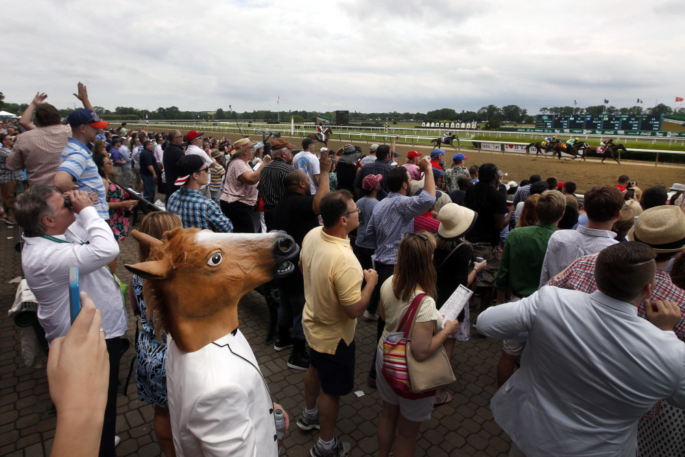 AP photo 
 A spectator wearing a horse mask watches the third race of the day on Saturday prior to the 147th running of the Belmont Stakes in Elmont, N.Y.
