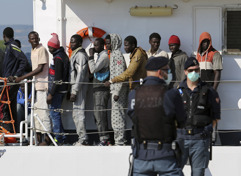 Migrants disembark from the Italian Coast Guard vessel Peluso as they arrive in the Sicilian port town of Augusta, Wednesday.