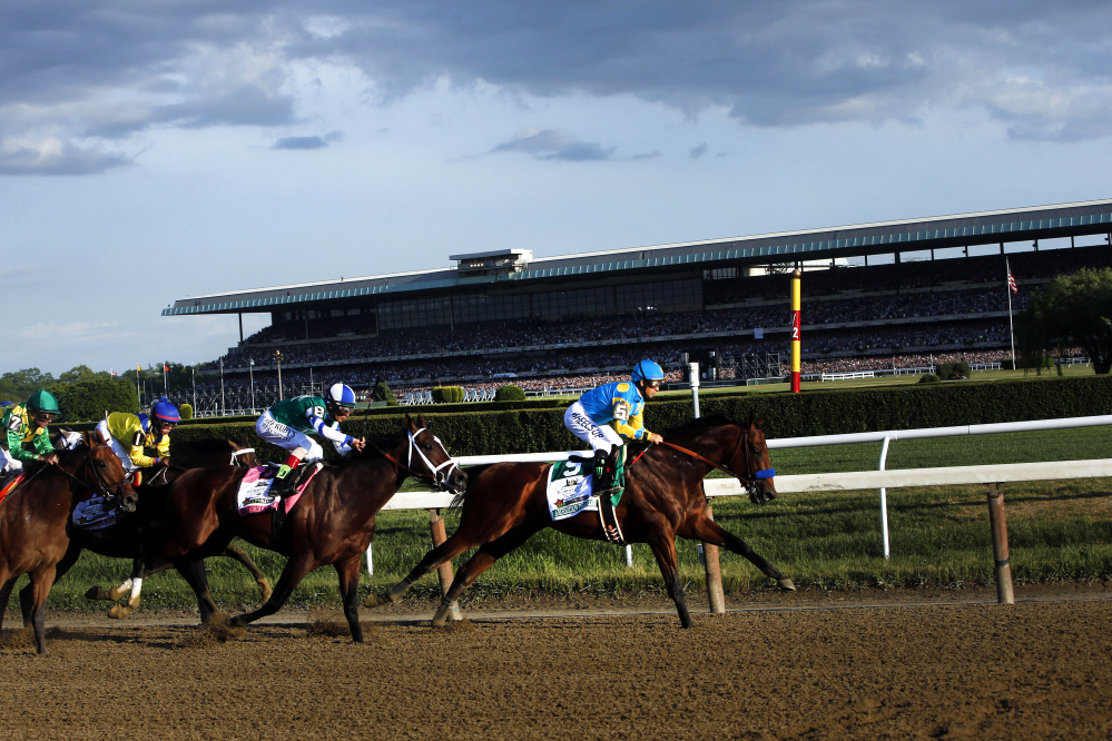 American Pharoah (5) leads the field entering turn three on the way to a Triple Crown victory during the 147th running of the Belmont Stakes horse race at Belmont Park, Saturday, in Elmont, N.Y.