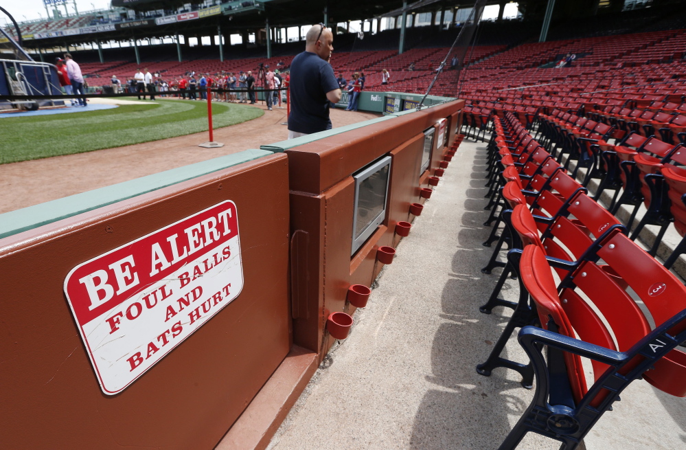 A warning sign is displayed in the stands at Fenway Park before a baseball game between the Boston Red Sox and the Oakland Athletics on Saturday in Boston. Tonya Carpenter of Paxton, Mass., was hit and seriously injured by a broken bat during the game Friday.