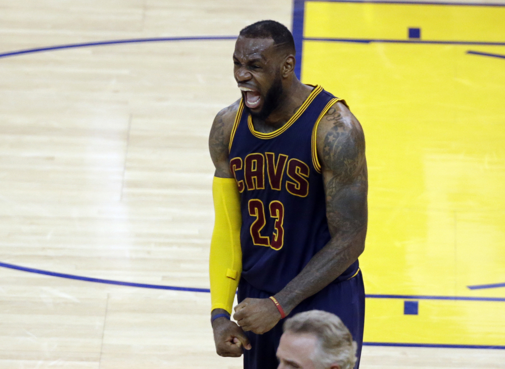 Cleveland’s LeBron James celebrates at the end of overtime in Game 2 of the NBA Finals against the Golden State Warriors on Sunday in Oakland, Calif. The Cavaliers won 95-93 in overtime.