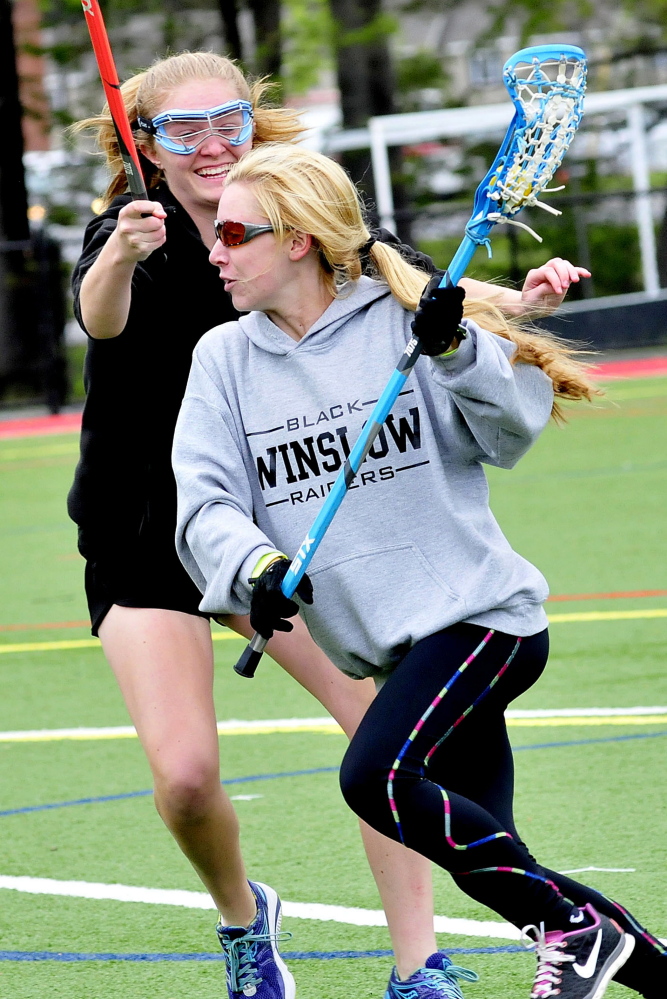 The Winslow High School girls lacrosse team practices Monday at Thomas College in Waterville. Callie Lavarnway, left, covers Cassidy Roderick.
