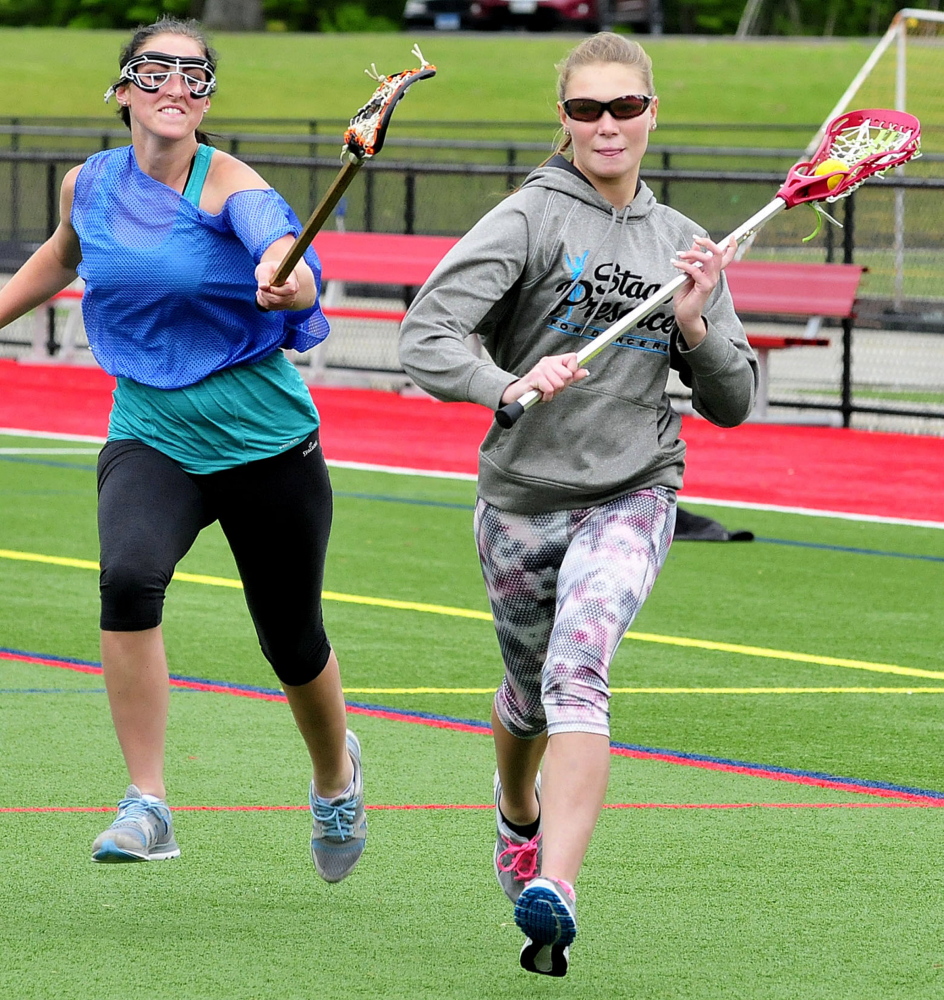 Winslow High School lacrosse players Victoria Lee-Bonsant, left, and Kameron Michaud run drills at practice Monday at Thomas College in Waterville.