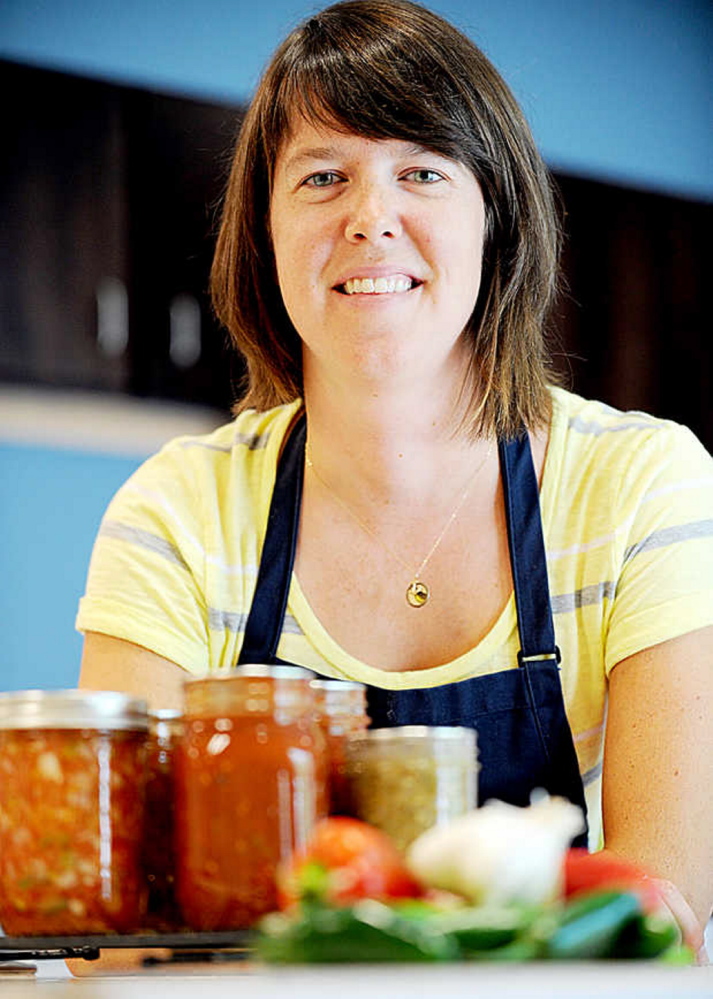 Kate McCarty, a food preservation program aide at the University of Maine Cooperative Extension, cans salsa and freezes tomatoes for use up to one year after preservation.
