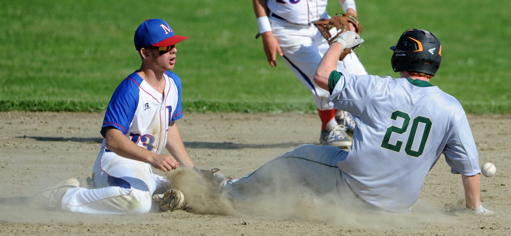 Staff photo by Michael G. Seamans 
 Oxford Hills' Emery Chickering (20) slides safely into second base as Messalonskee's Ben Frazee tries to dig the ball out of the dirt during an Eastern A quarterfinal game Thursday in Oakland.