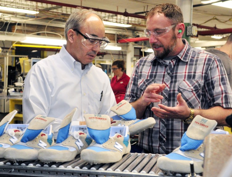 U.S. Rep. Bruce Poliquin, left, and plant manager Chuck Campbell discuss shoes April 10 during a tour of the New Balance factory in Norridgewock.