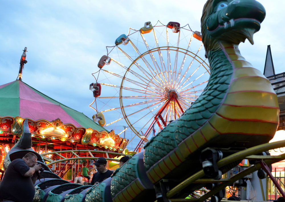 Inspectors from the Office of the State Fire Marshal investigate a ride malfunction at the Smokey’s Greater Shows carnival at Head of Falls in Waterville on Friday. The ride, the Dragon Wagon, will be closed as the investigation continues, officials said Saturday.