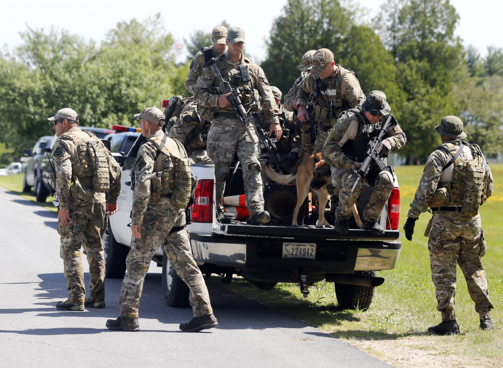The Associated Press Law enforcement officers get off a truck as they return to their vehicles after searching a wooded area on Sunday in Schuyler Falls, N.Y.
