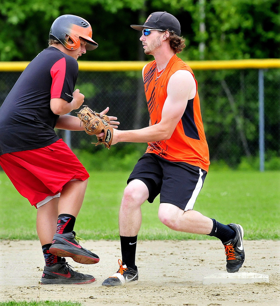 Winslow High School shortstop Alex Berard, right, tags a baserunner out during practice Monday.