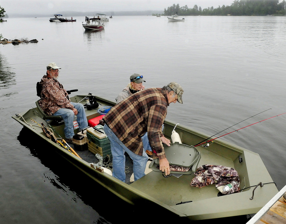 Veteran Frank Evangelista, of Solon, right, gets into a fishing boat Tuesday with his daughter, Lori Geib, of Carrabassett Valley, to fish on Great Pond in Belgrade as part of the Fishing Extravaganza for area veterans while volunteer boat operator Terry Huffman backs away.