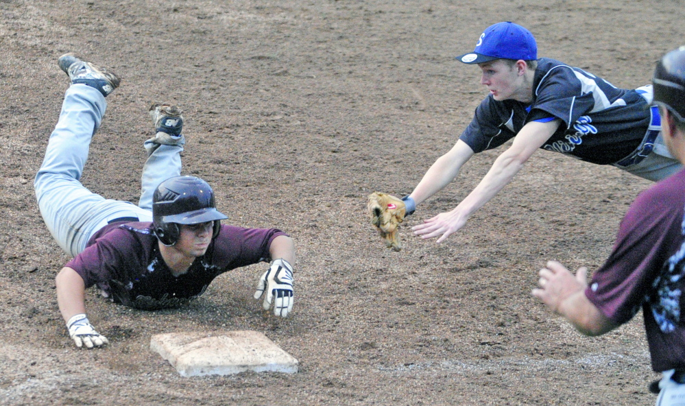 Richmond baserunner Curtis Anderson dives back to first before Searsport first baseman Liam MacMIllan can apply the tag during the Western D title game Tuesday at Larry Mahaney Diamond at St. Joseph’s College in Standish.