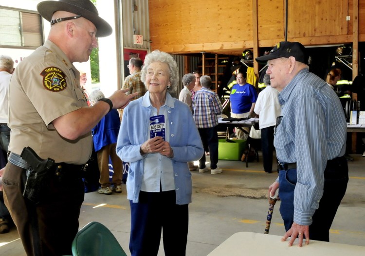 Franklin County Sheriff Scott Nichols speaks with Gloria and Lincoln Grush, of Jay, on Thursday during the Senior Resource Fair at Wilton’s Public Safety Building.