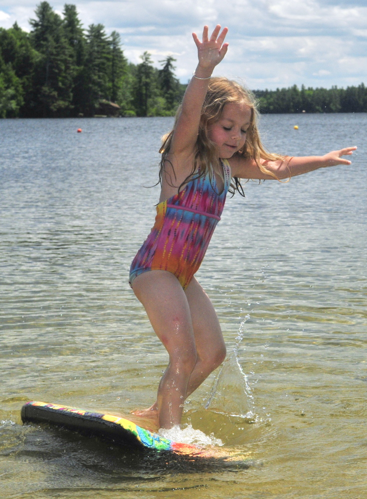 Shae LePage tries out her boogie board Friday in Maranacook Lake at the Readfield Town Beach in Readfield.