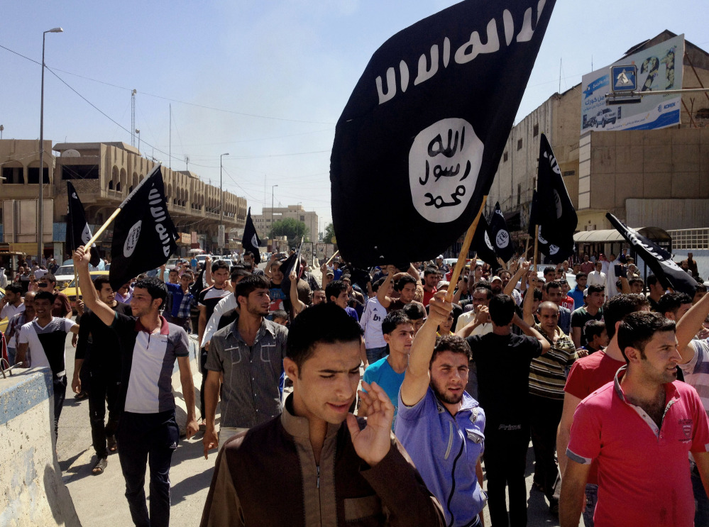 In this Monday, June 16, 2014 file photo, demonstrators chant pro-Islamic State group slogans as they wave the group’s flags in front of the provincial government headquarters in Mosul, 225 miles (360 kilometers) northwest of Baghdad, Iraq. )