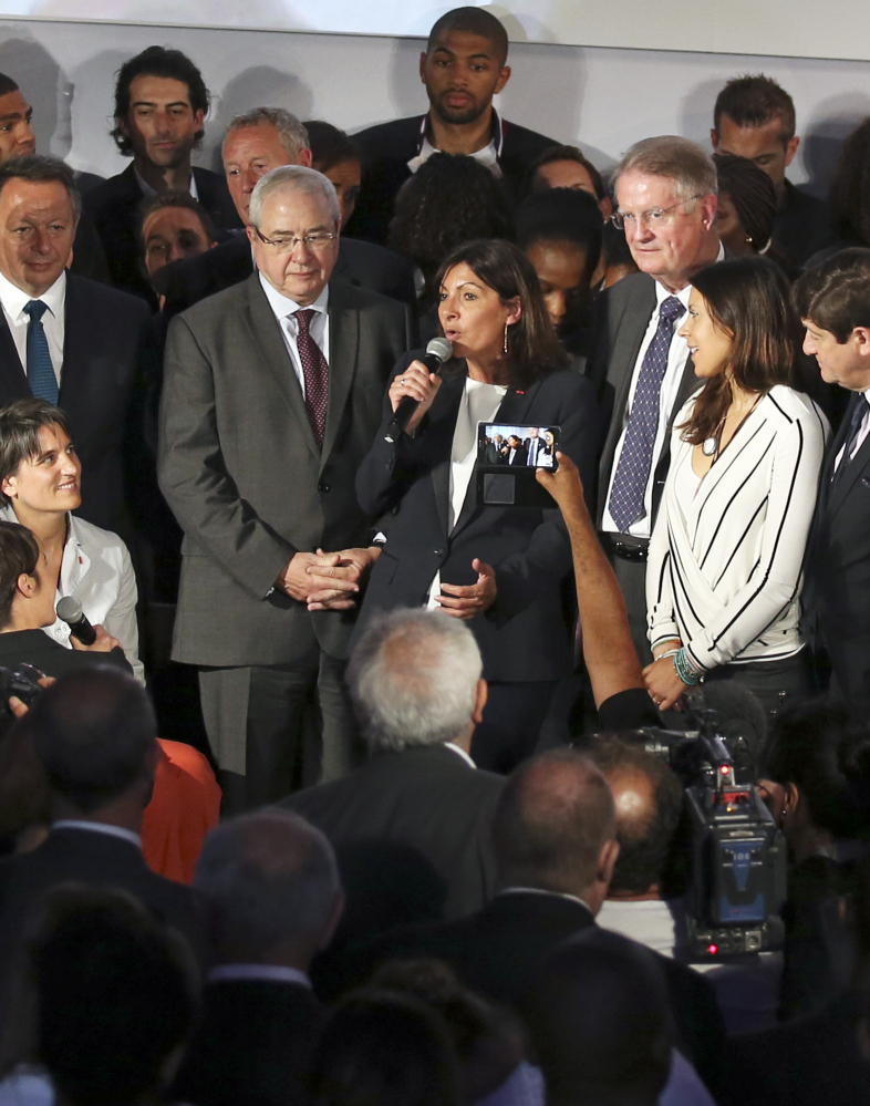 Paris mayor Anne Hidalgo, center, announces the candidacy of Paris for the 2024 Olympic games, in Paris, Tuesday.
