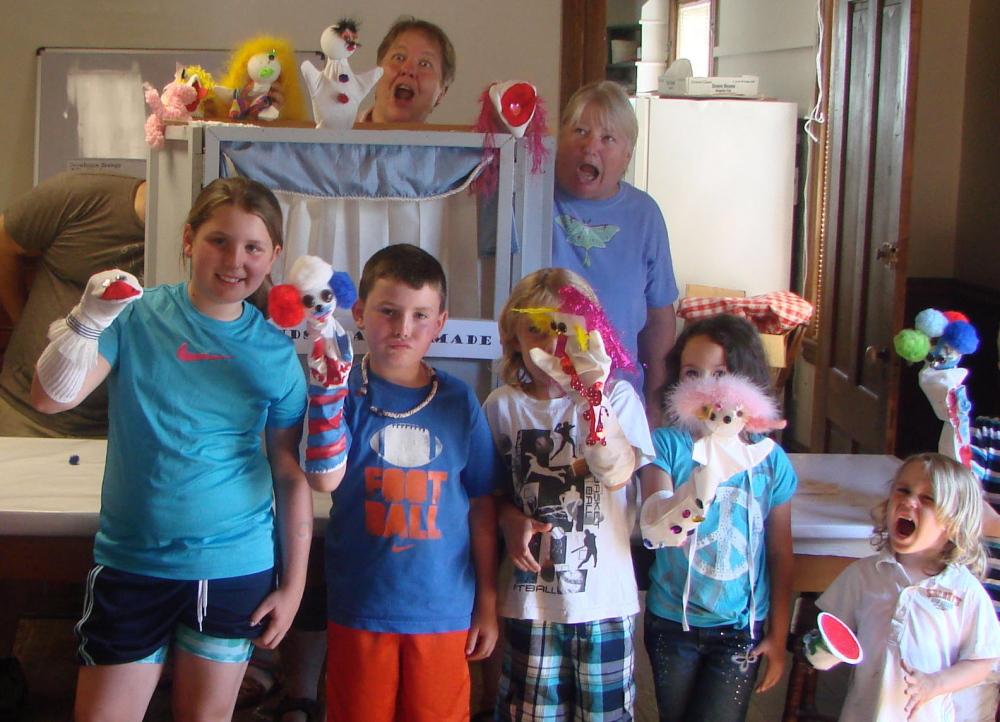 Debby Beckwith-Noonan, at rear behind the puppet theater, goofs around with kids at a puppet workshop at the Canaan Farmers Hall as part of a children’s day event that she organized in 2012. Noonan, who was injured in a car accident in March, died Sunday of her injuries.