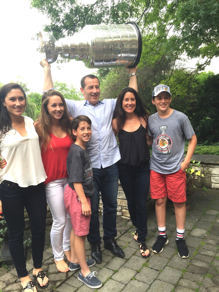 Former Portland Pirates coach Kevin Dineen and his family, from left, Hannah, Emma, Declan, Kevin, Annie and William, share a moment with the Stanley Cup in the backyard of Chicago head coach Joel Quenneville last week in Hinsdale, Illinois.