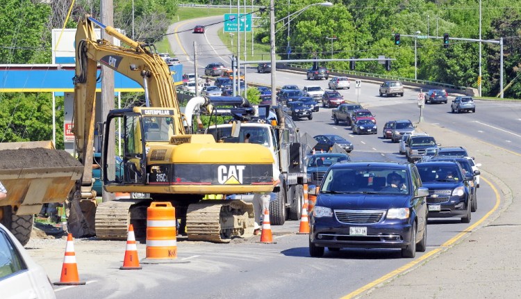 Westbound traffic on Western Avenue narrows to a single lane on Wednesday as drivers go around a crew repairing a water main break near the Homewood Suites motel construction site.