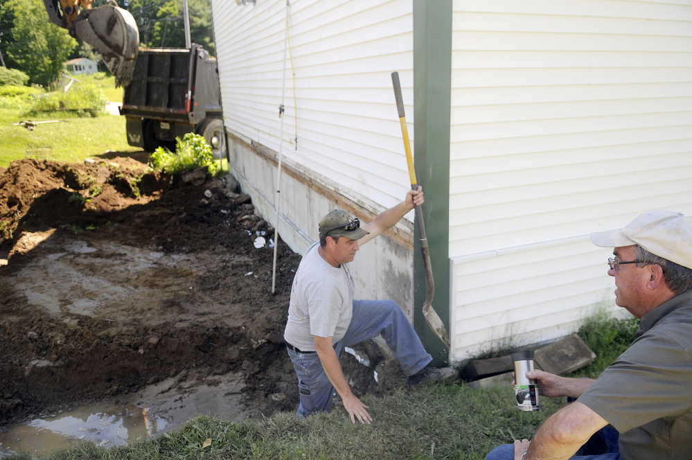 Todd Dunn climbs out of an excavation hole behind the Mount Vernon Fire and Rescue station as work to expand the structure began Wednesday. At right is his brother, Dana Dunn, Mount Vernon’s fire chief, who is overseeing the project.