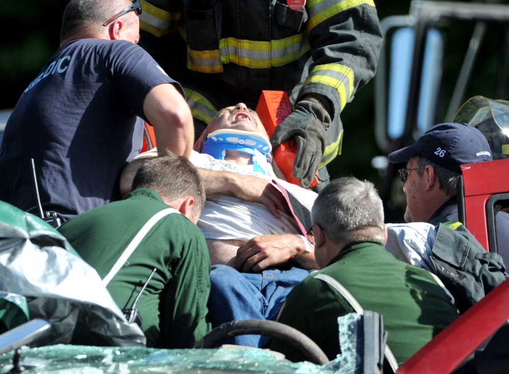 Rescue workers from Norridgwock fire department and LifeFlight extract a man from his car Friday after a three-vehicle collision on Route 139 in Norridgewock on Friday,.