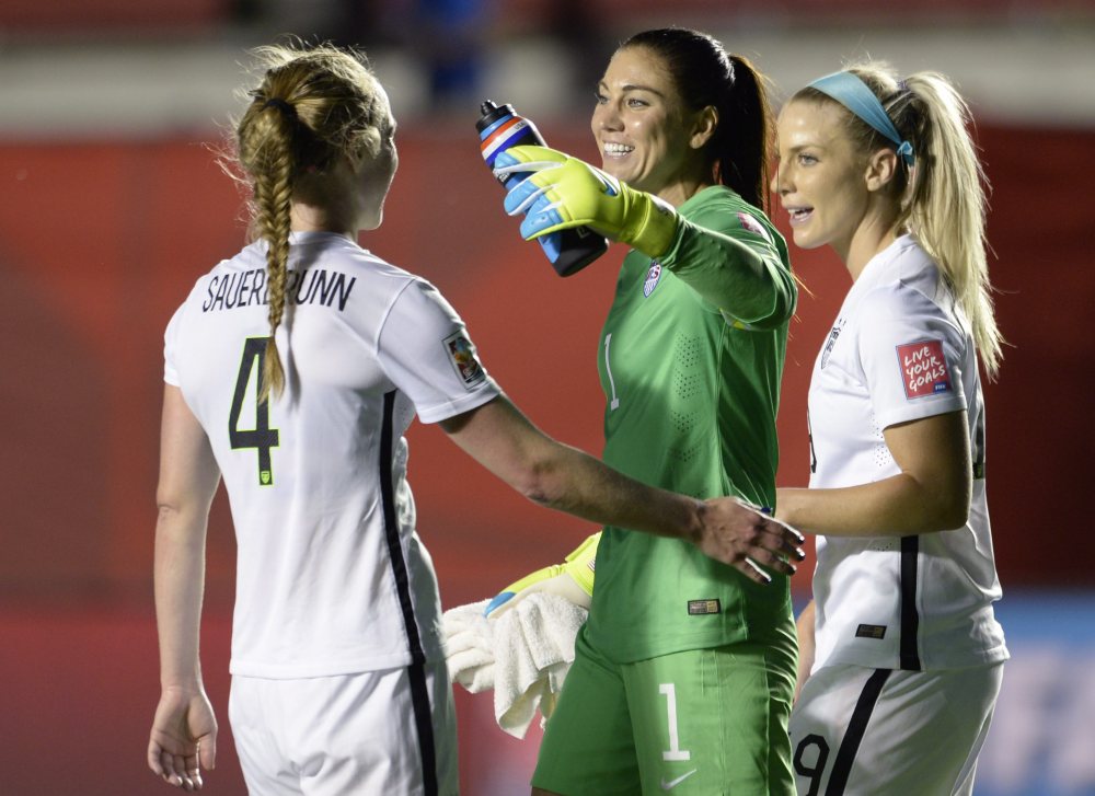U.S. goalie Hope Solo and teammates Julie Johnston (19) and Becky Sauerbrunn (4) celebrate the team’s win over China in a quarterfinal match Friday in the FIFA Women’s World Cup in Ottawa, Ontario, Canada.