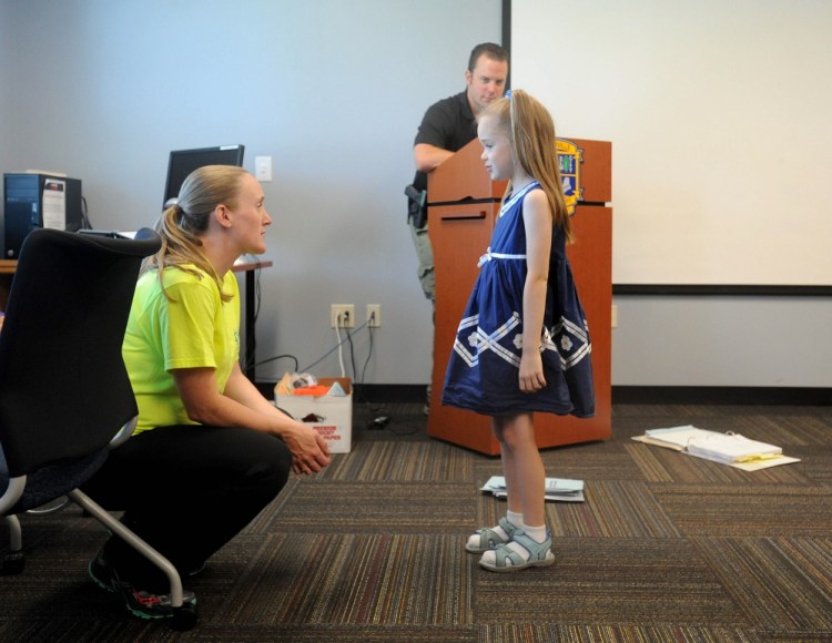 Sgt. Jennifer Weaver of the Waterville Police Department works through a lost-in-public demonstration with Dominique Giroux-Pare, 6, in the radKIDS Personal Empowerment Safety Education class at the Waterville police station on Wednesday. Waterville police Officer Damon Lefferts is shown helping with the role-playing in background.